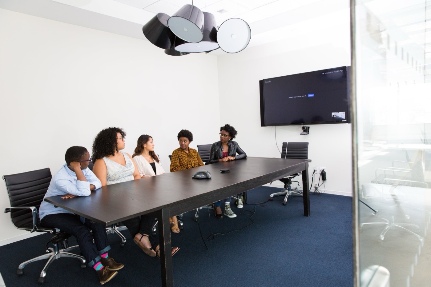 Professionals collaborating in a glass conference room.