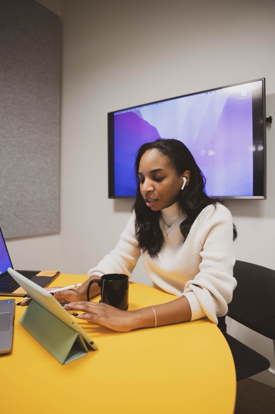 Team member using a tablet at an office table.