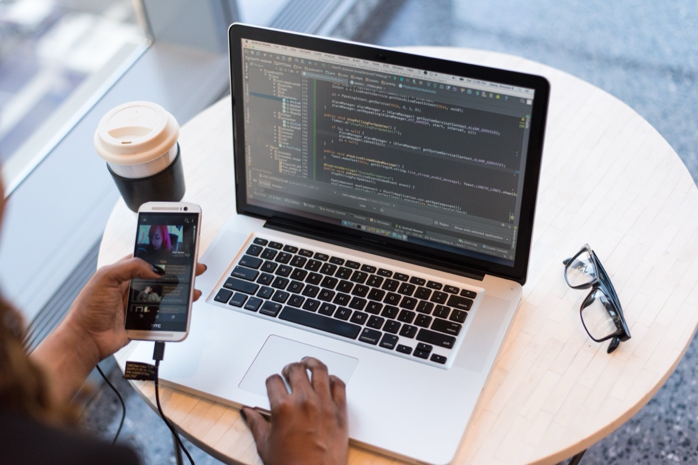Hands coding on a laptop with an IDE open.
