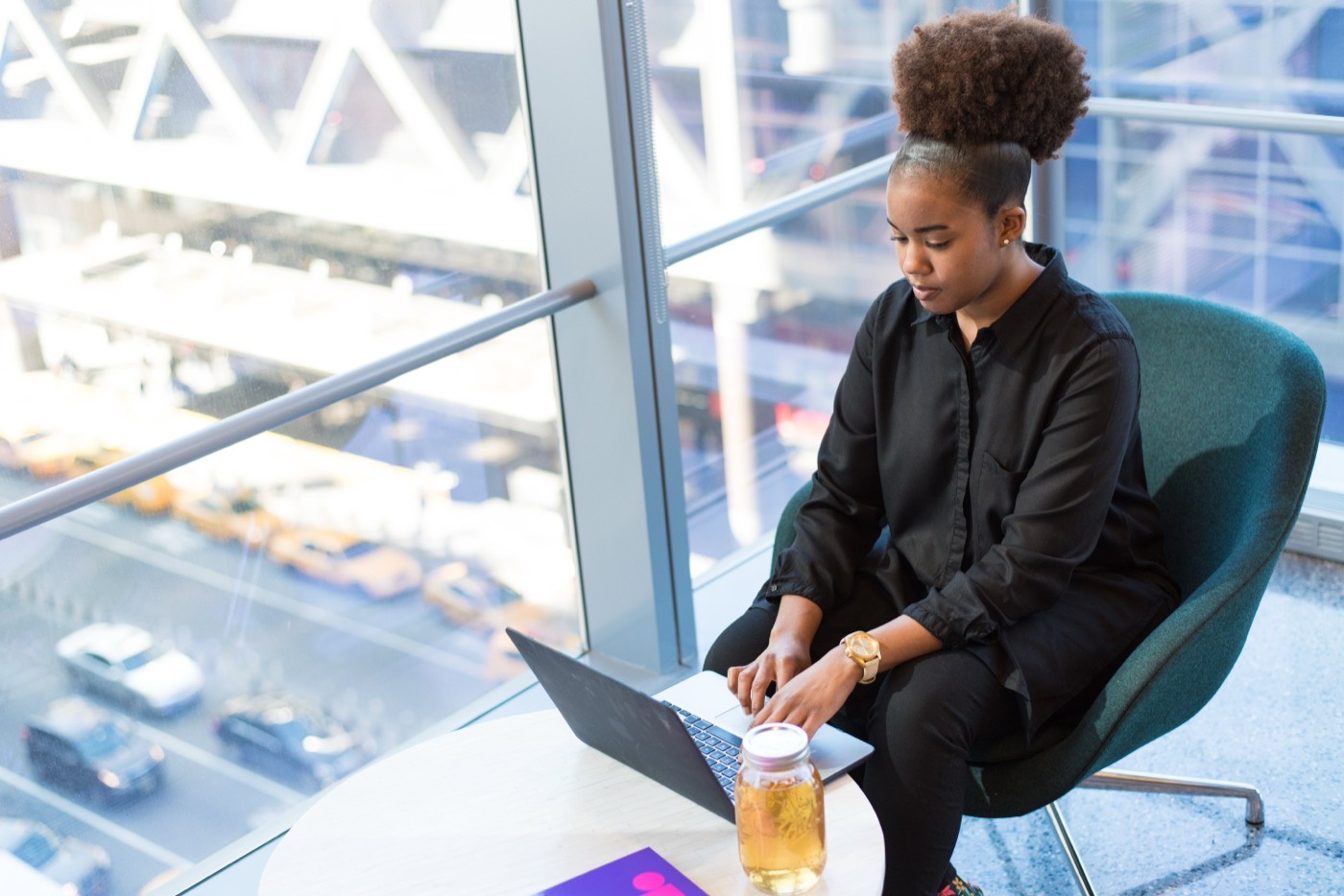 Learner coding on a laptop by a window.