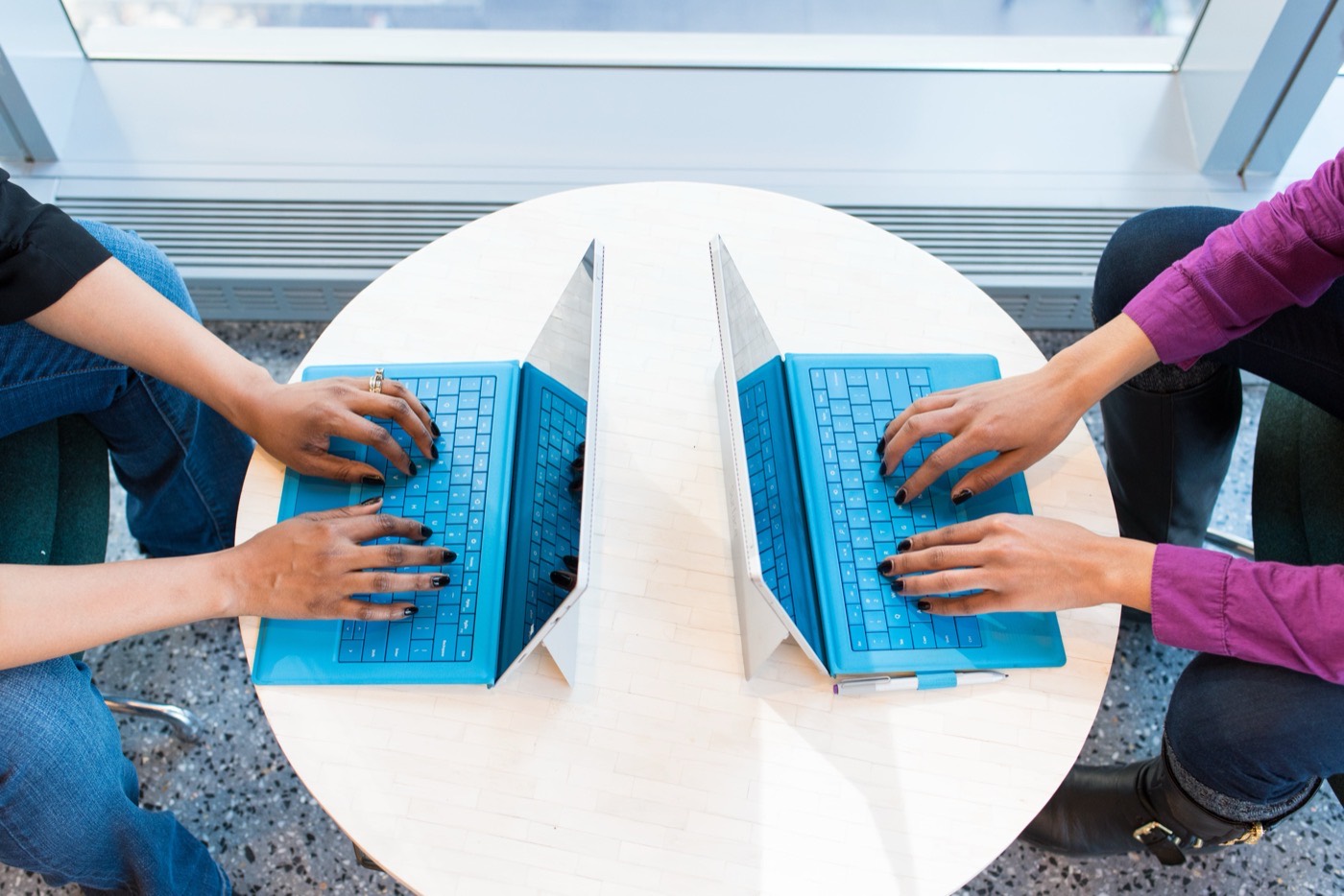 Two people pair-programming on matching laptops.